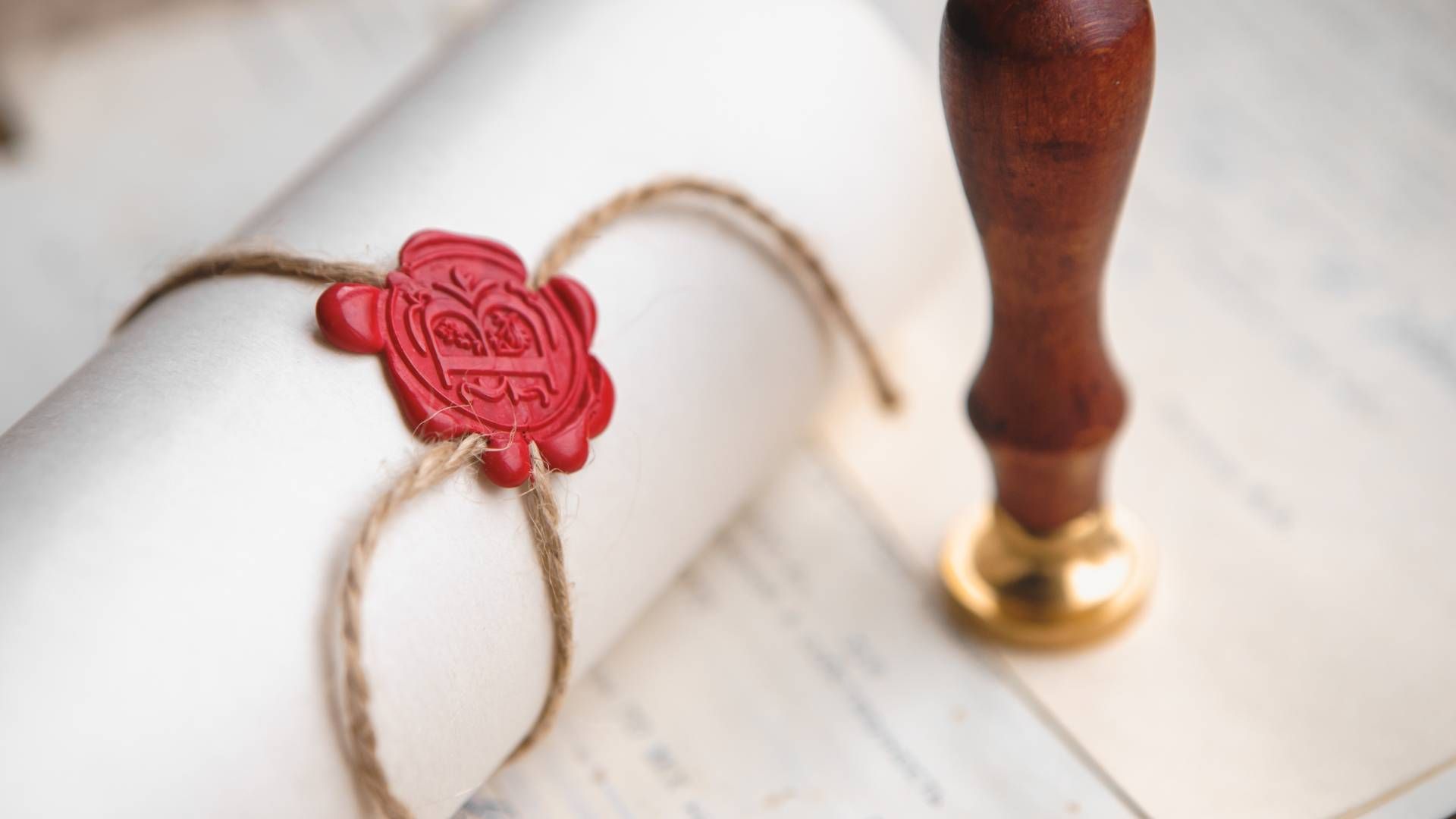 A roll of paper with a red wax seal and a stamp on it.