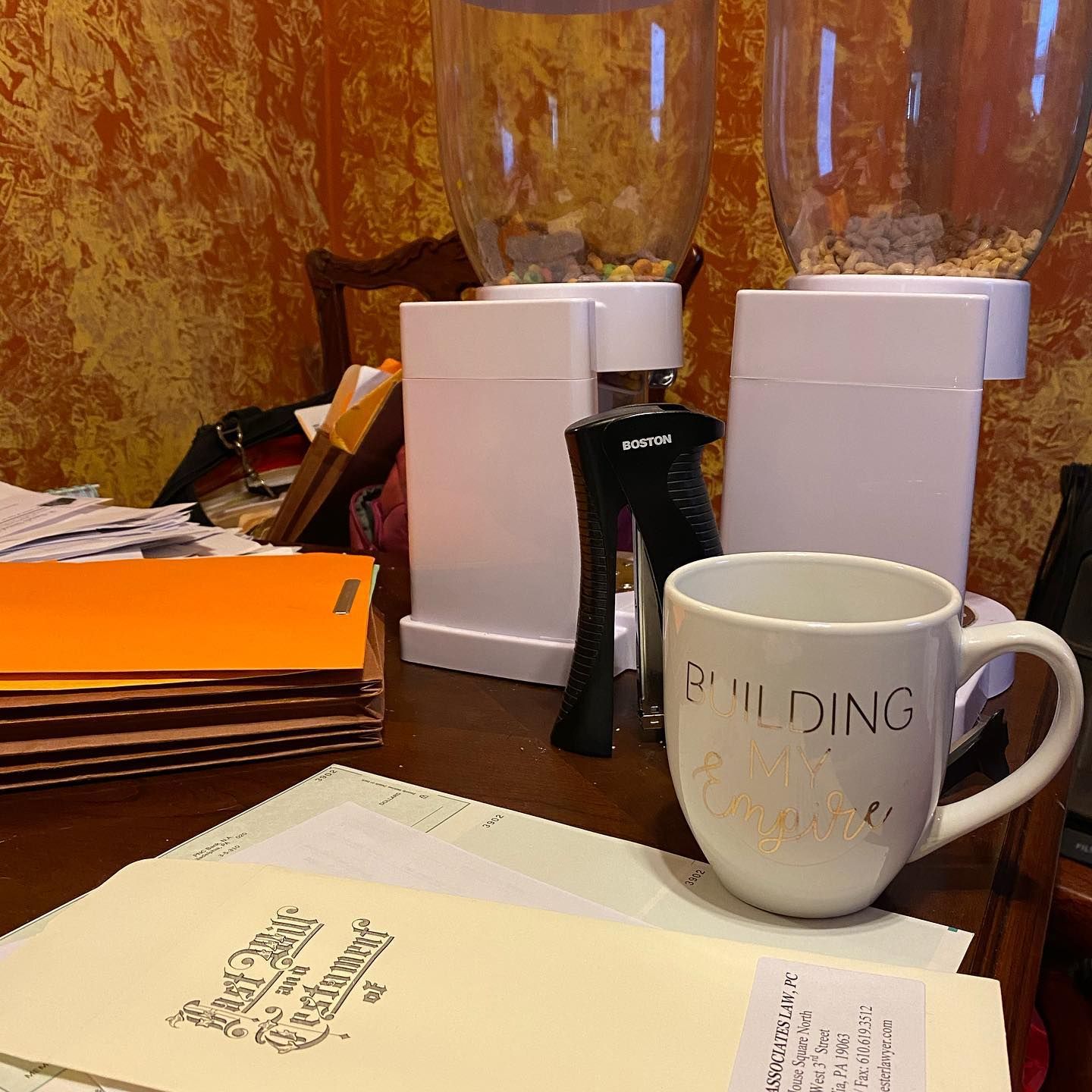 A coffee mug that says building on it sits on a desk