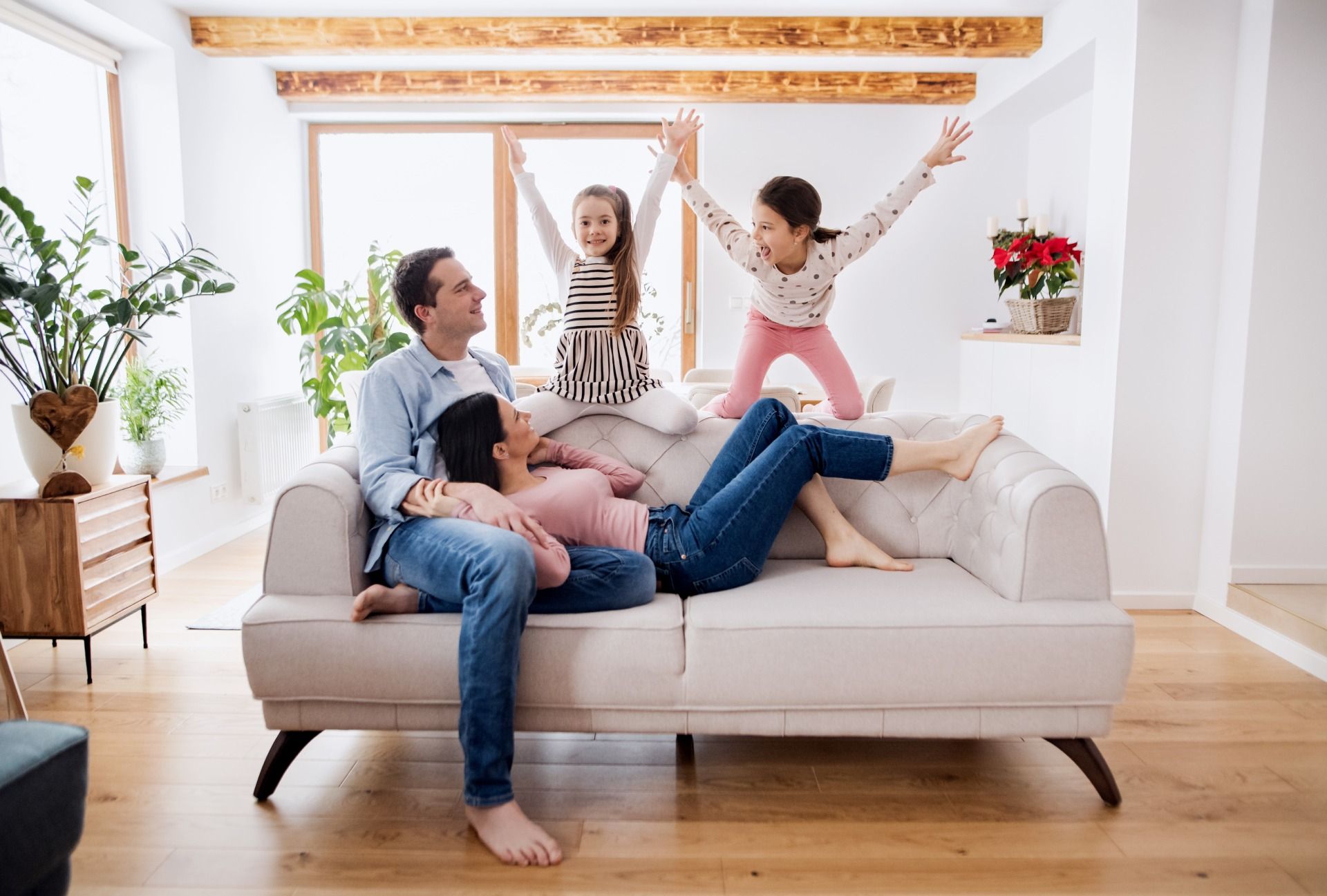 A family is sitting on a couch in a living room.