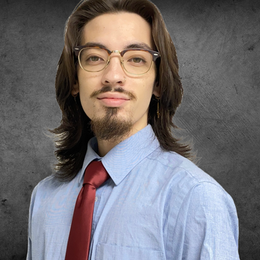A man in a suit and white shirt is leaning against a wall.