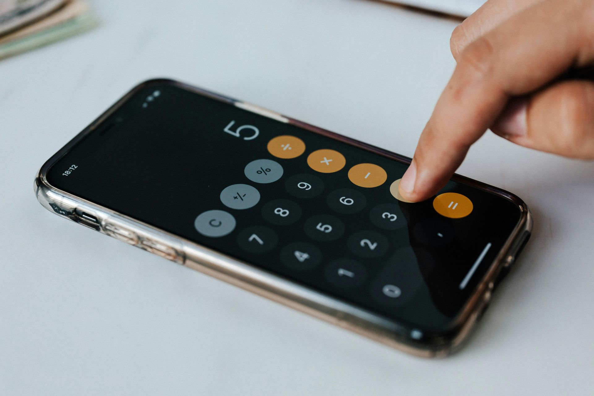 A person is using a calculator on a cell phone.