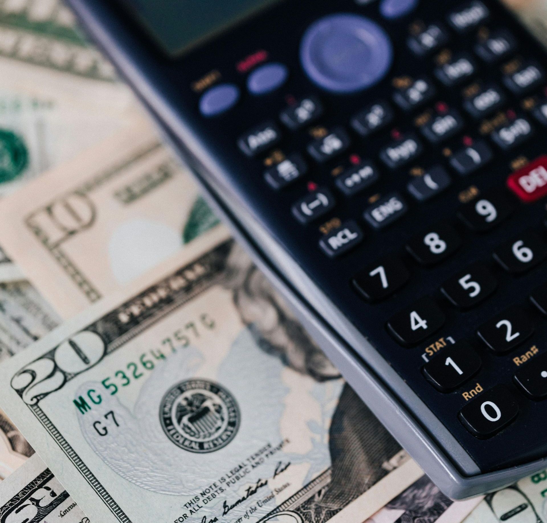 A calculator is laying on top of a 20 dollar bill