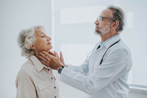 A doctor is examining an older woman 's thyroid gland.