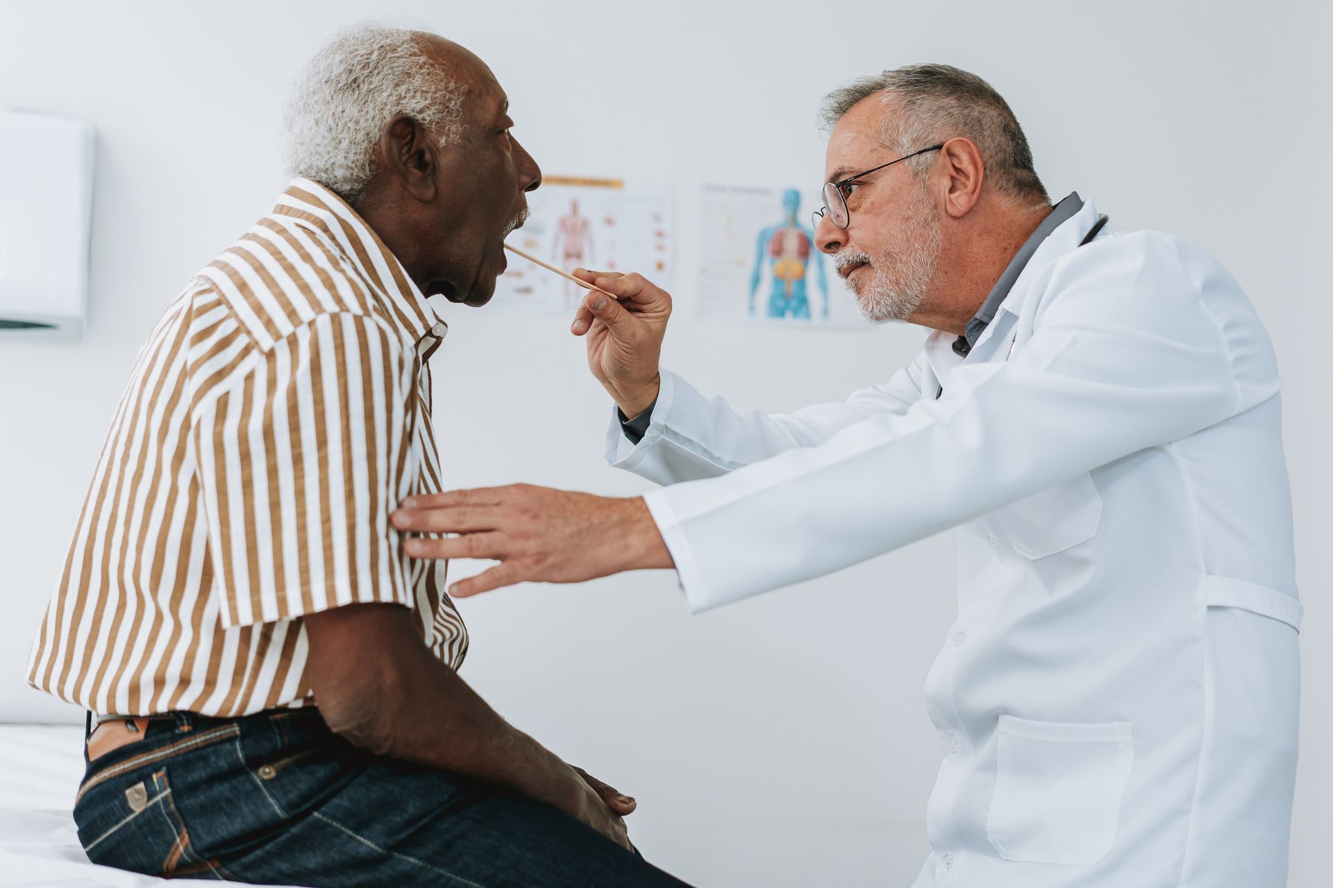 A doctor is examining a patient 's throat with a tongue depressor.