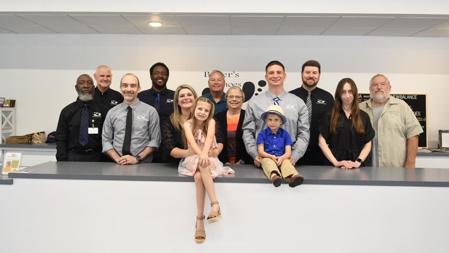 A group of people are posing for a picture in front of a counter.