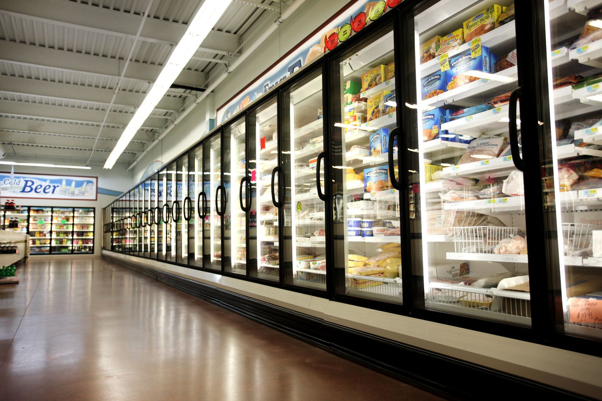 Commercial refrigeration units keeping frozen food cold in a grocery store.