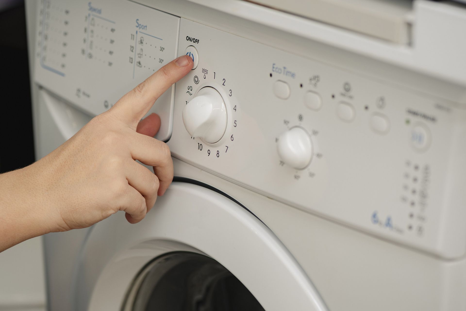 Hand Of Person Adjusting Washing Machine Knob — Sunnyvale, CA — All Appliance & HVAC Service, Inc.
