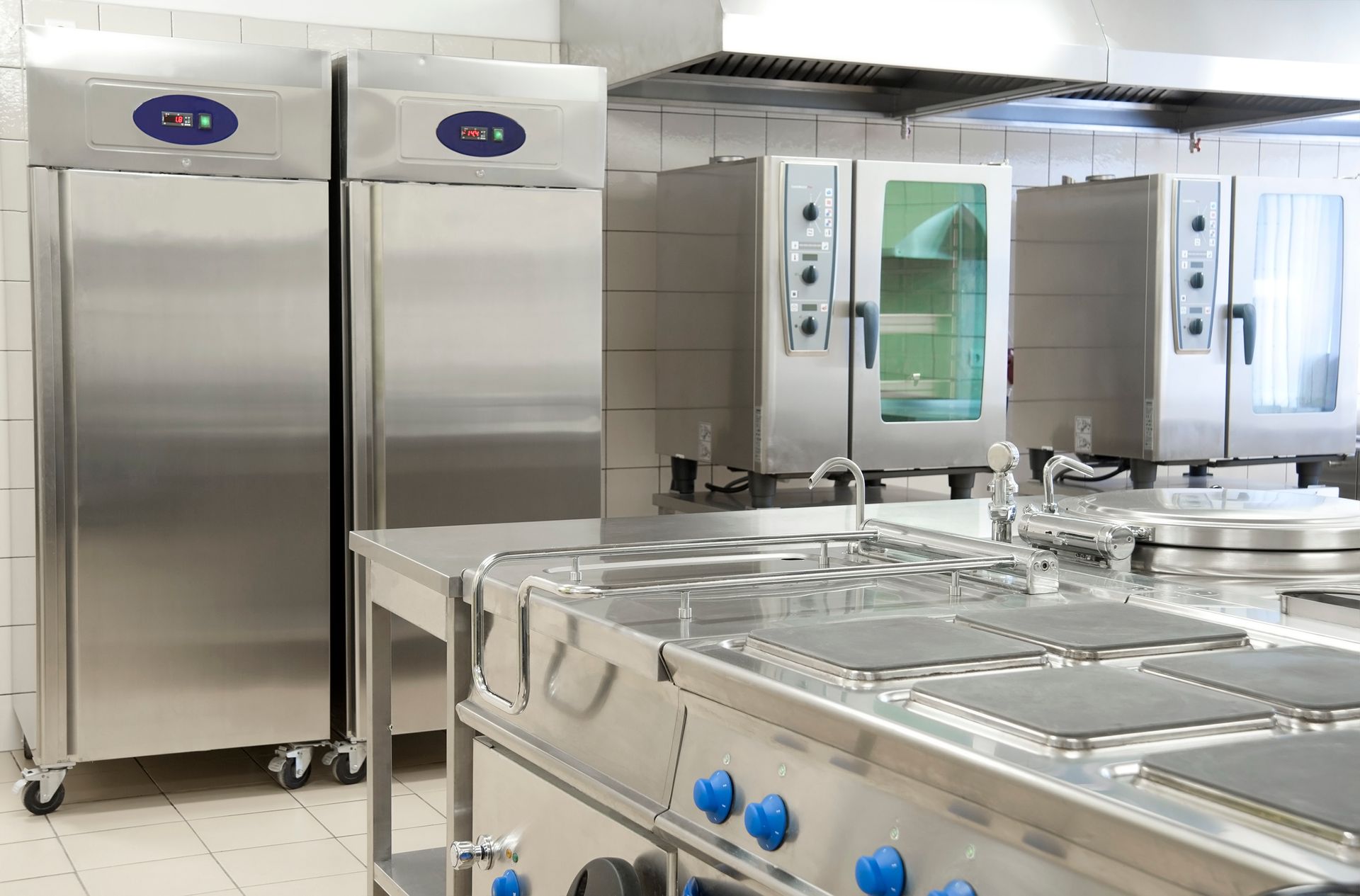 Empty restaurant kitchen with professional equipment, showcasing commercial refrigeration repair. Empty restaurant kitchen with professional equipment, showcasing commercial refrigeration repair.