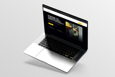 Open laptop displaying a dark website on a silver background