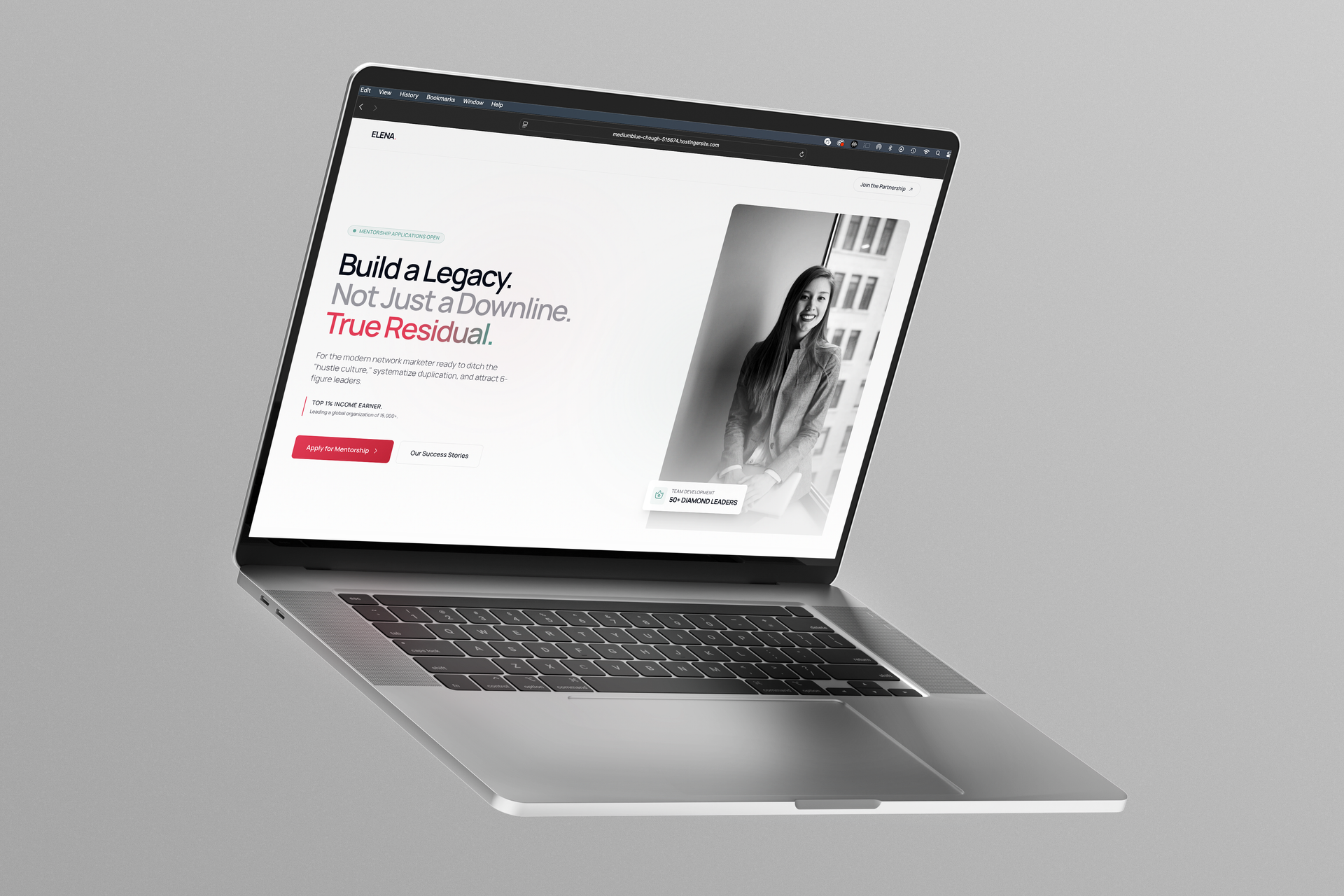 Silver laptop displaying a clean black-and-white website on a gray background