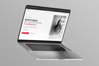 Silver laptop displaying a clean black-and-white website on a gray background