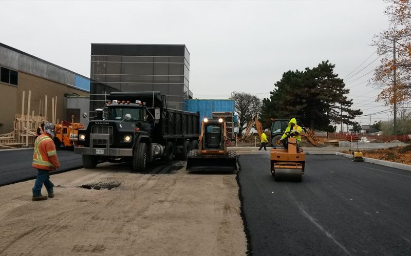 A group of construction workers are working on a road.