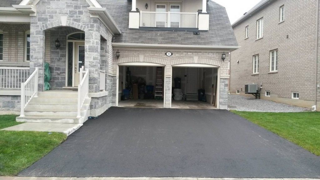 A house with two garages and a driveway in front of it