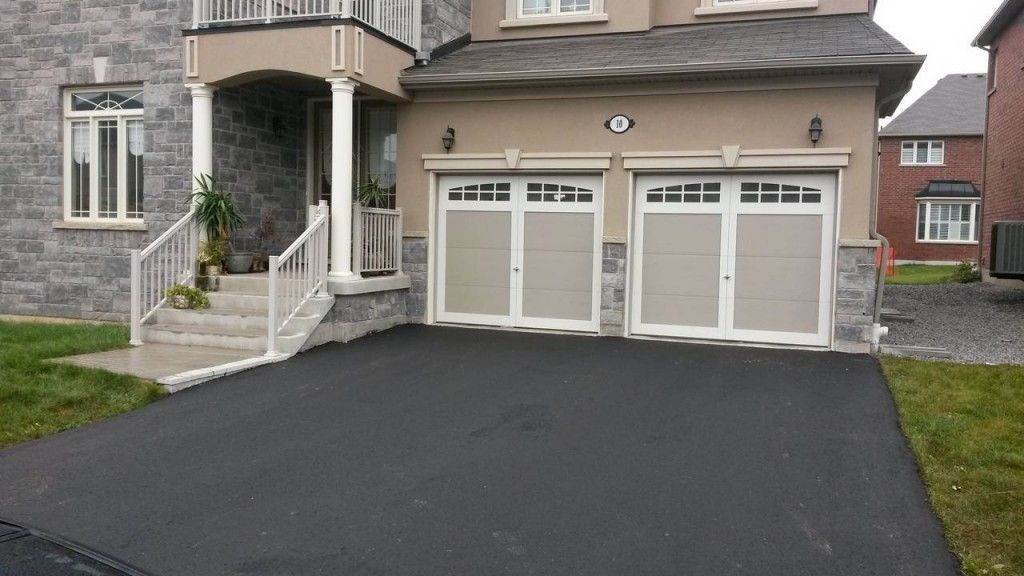 A house with three garage doors and a black driveway