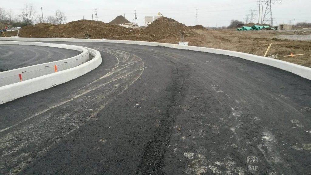 A road that is being built with a lot of dirt in the background.