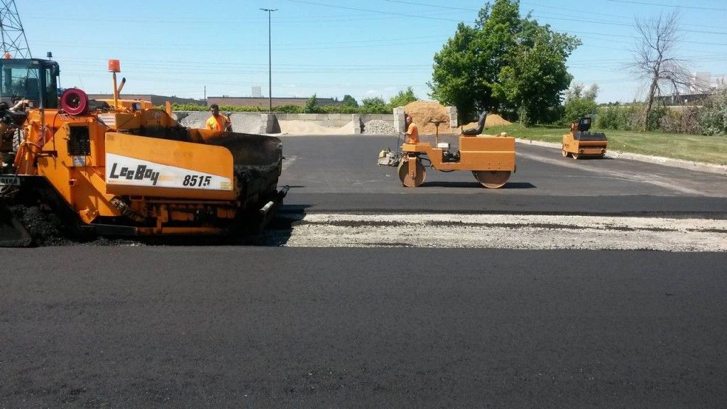 A road is being paved with a machine that says leroy on it