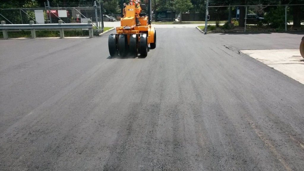 A yellow tractor is driving down a road