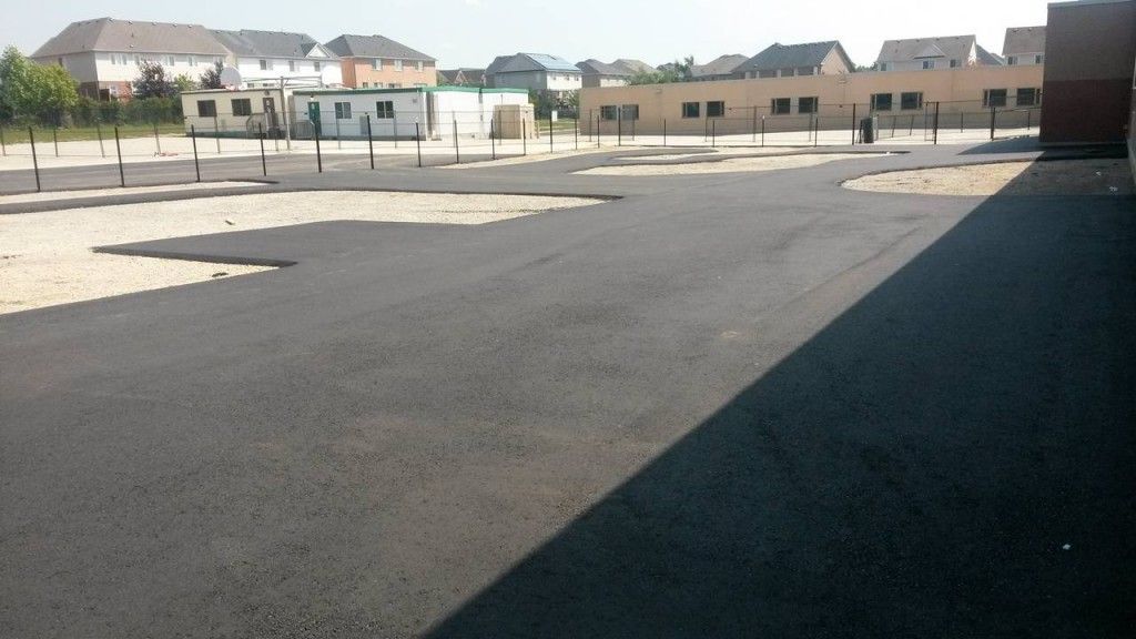 A shadow of a building is cast on the asphalt