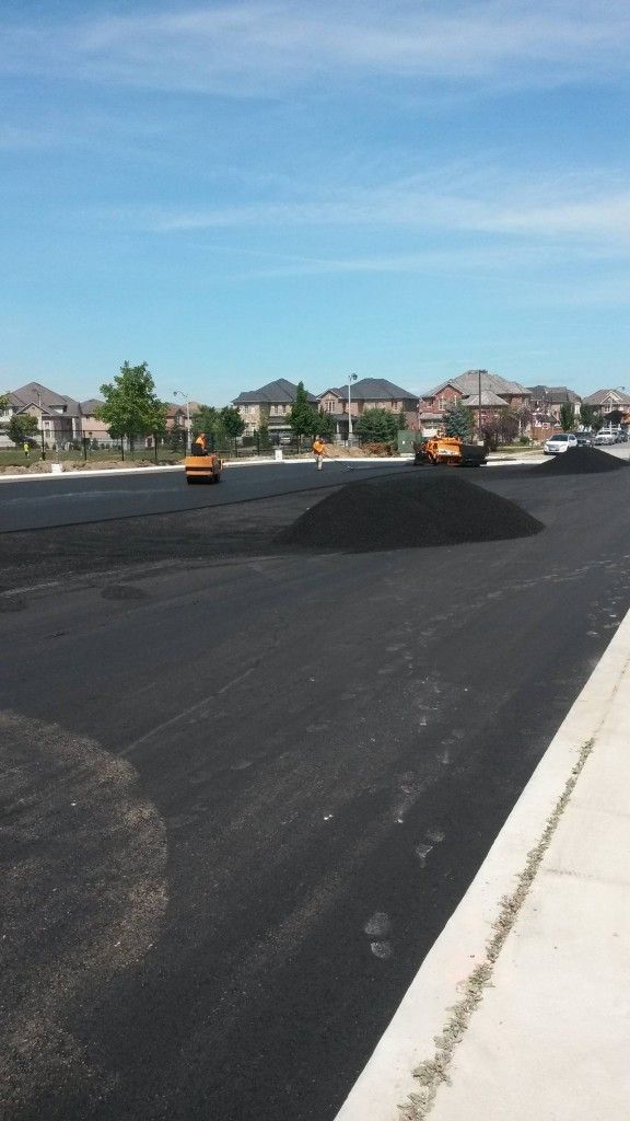 A large pile of asphalt is sitting on the side of a road.
