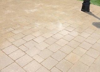 A brick walkway with a lamp post in the background.