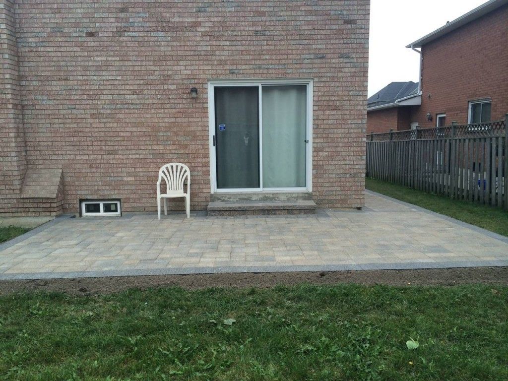 A brick house with a patio and a chair in front of it