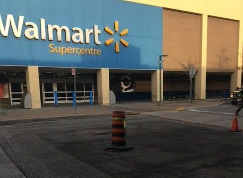 A walmart supercentre is located on the corner of a street