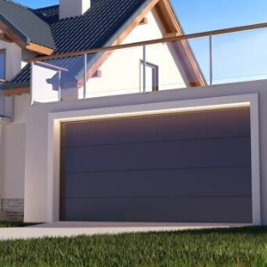 A modern house with a large, dark gray horizontal-panel garage door and a glass-railed balcony above.