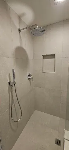 A bathroom with a shower head and a sink.