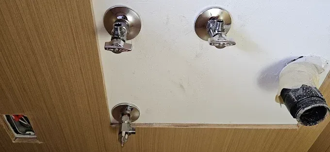 A close up of a bathroom sink with faucets hanging from the ceiling.
