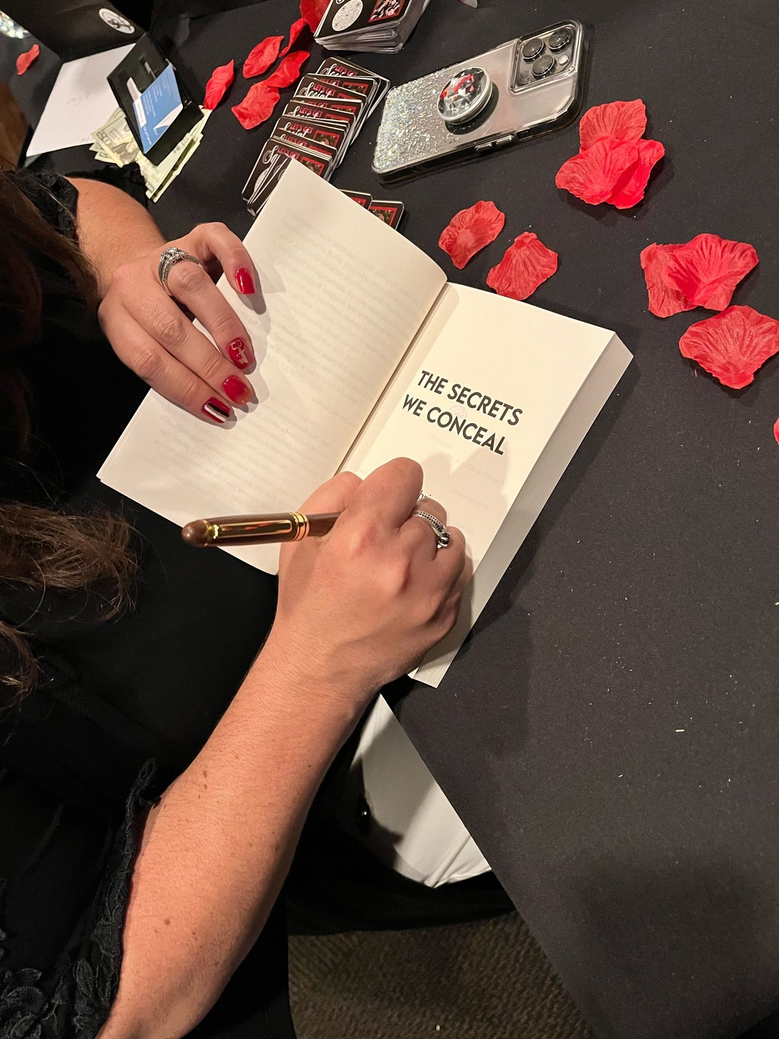 A woman is signing a book with a pen
