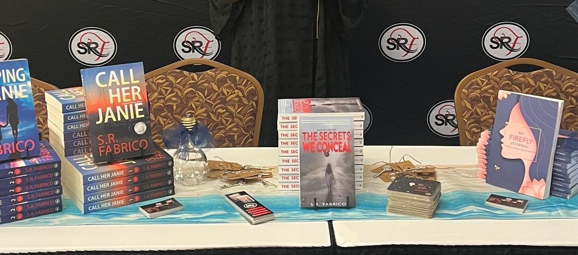 A table with a bunch of books on it and a sign that says `` call her janie ''.
