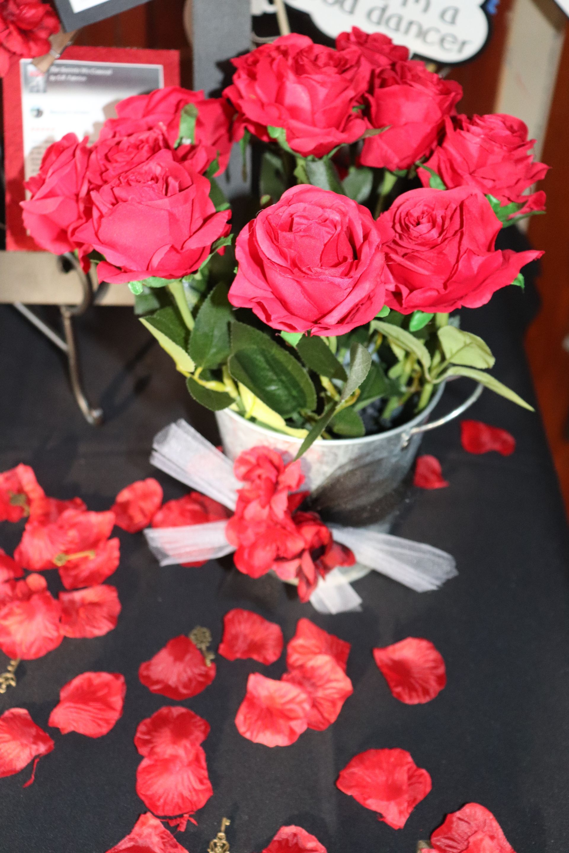 A bunch of red roses in a bucket on a table