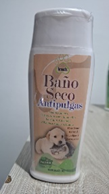 Una botella de champú para perros está sobre una mesa de madera.