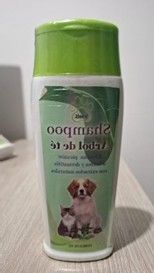 Una botella de champú para perros está sobre una mesa de madera.