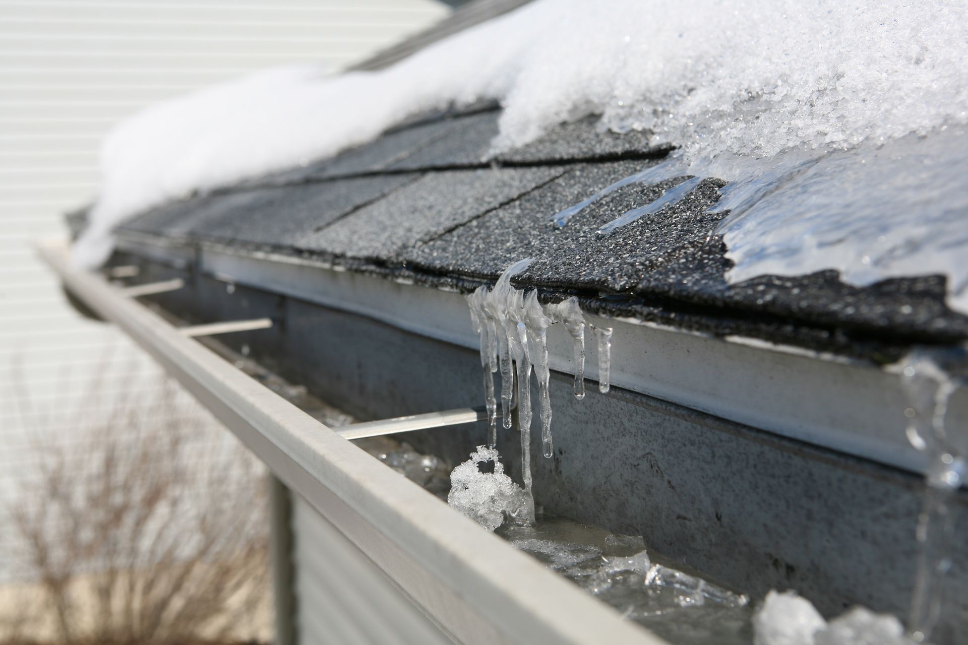 Snow and icicles on a roof gutter in winter.