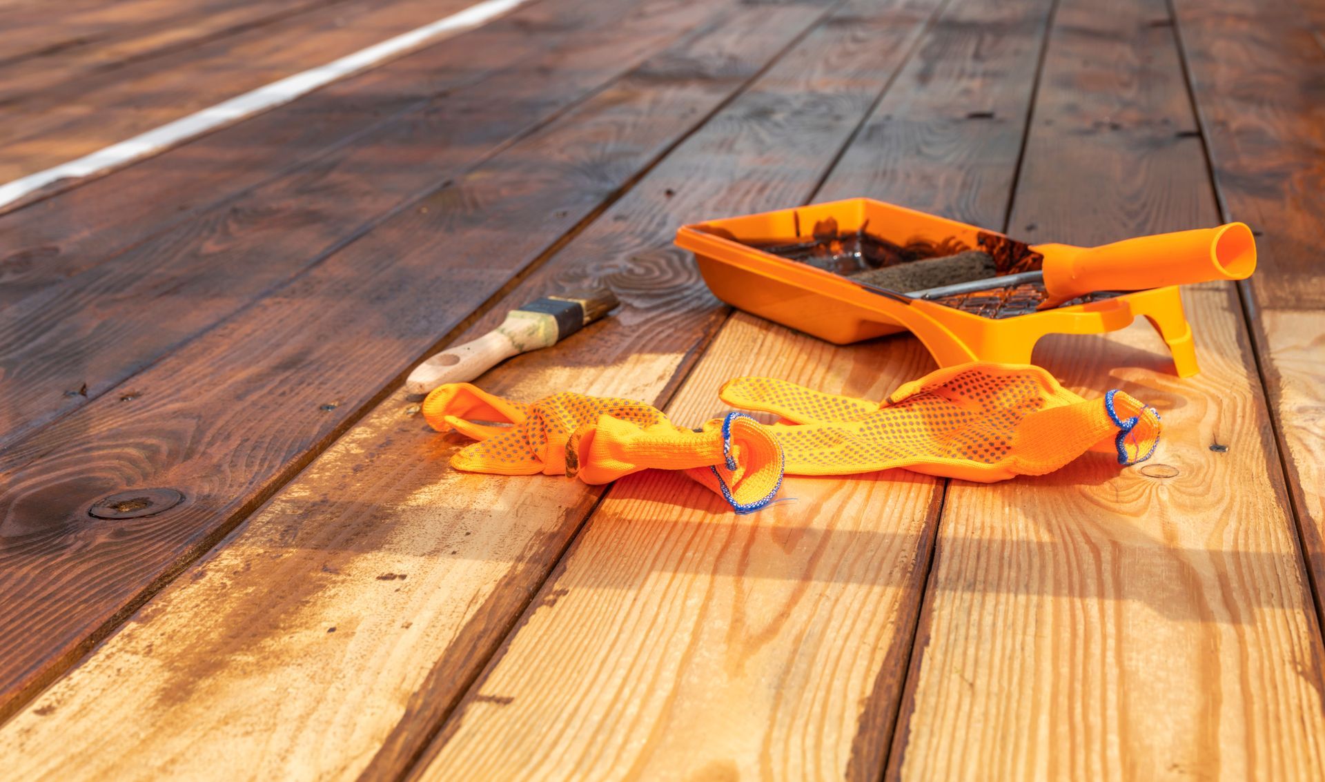 Black wrought iron fence with fleur-de-lis finials. Houses and a pathway are in the blurry background.