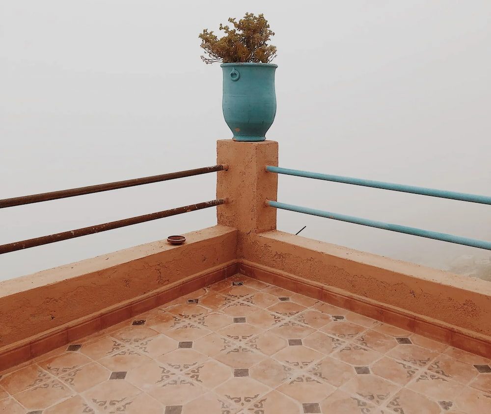 Corner of a Terrace With Brown Tile, Turquoise Railing, and a Flowerpot — Unique Waterproofing Solutions in North Rocks, NSW