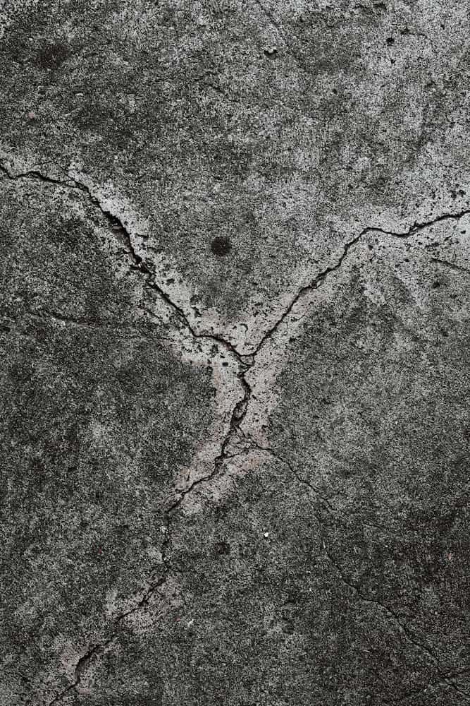Cracked, Gray Concrete Surface With Dark Patches — Unique Waterproofing Solutions in North Rocks, NSW