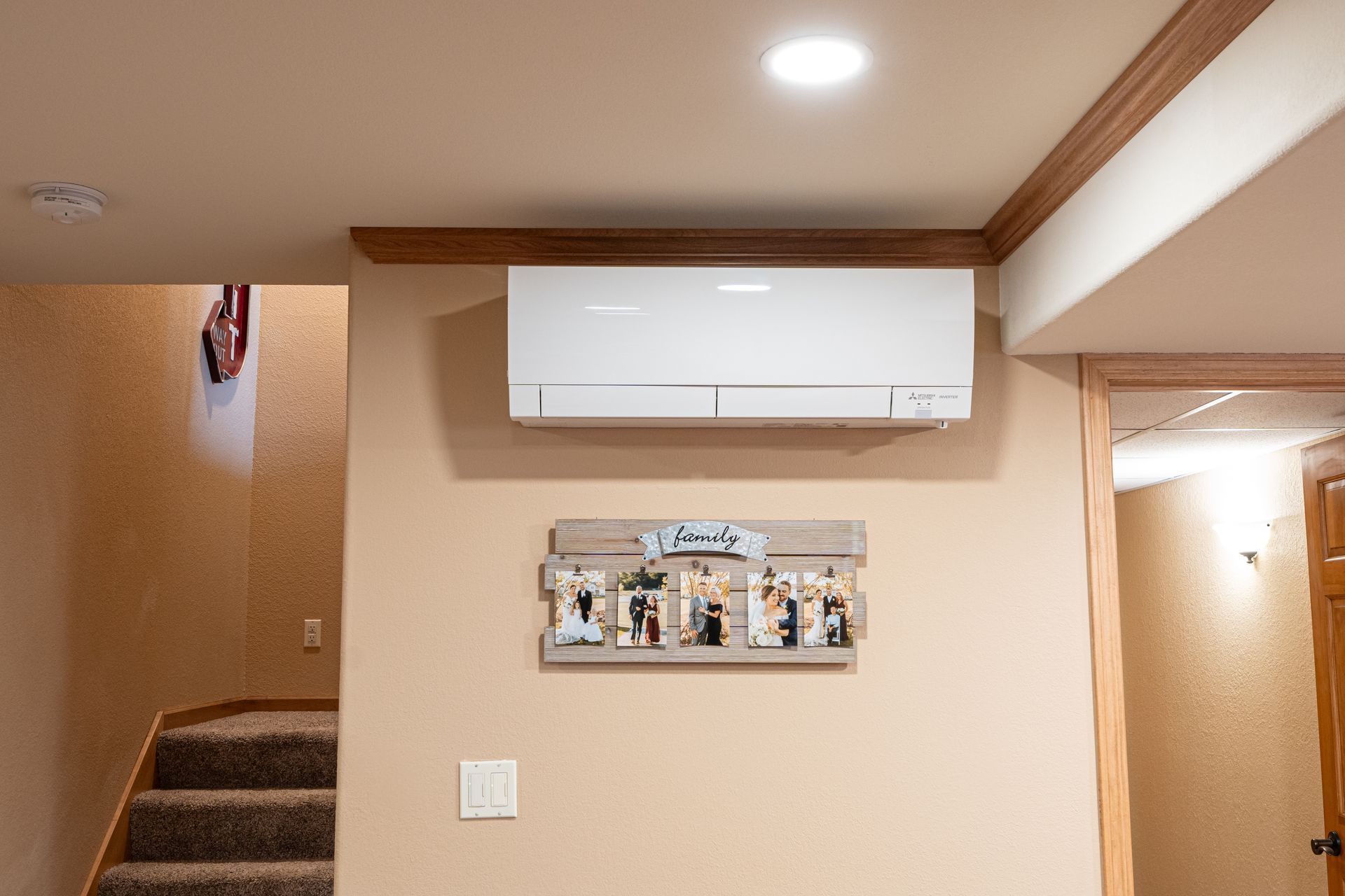 A white air conditioner is sitting on the side of a blue house.