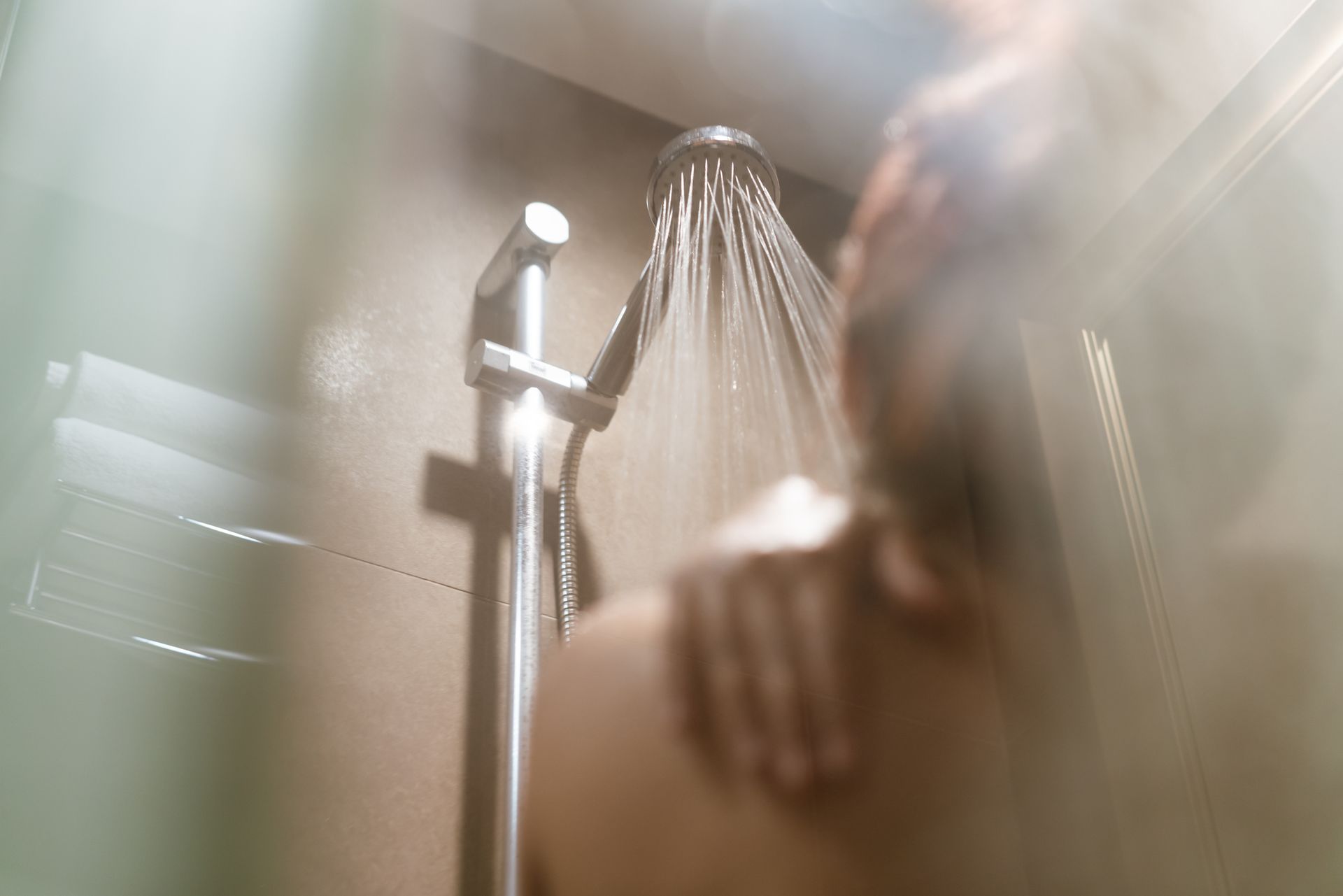 A person is taking a shower in a bathroom.