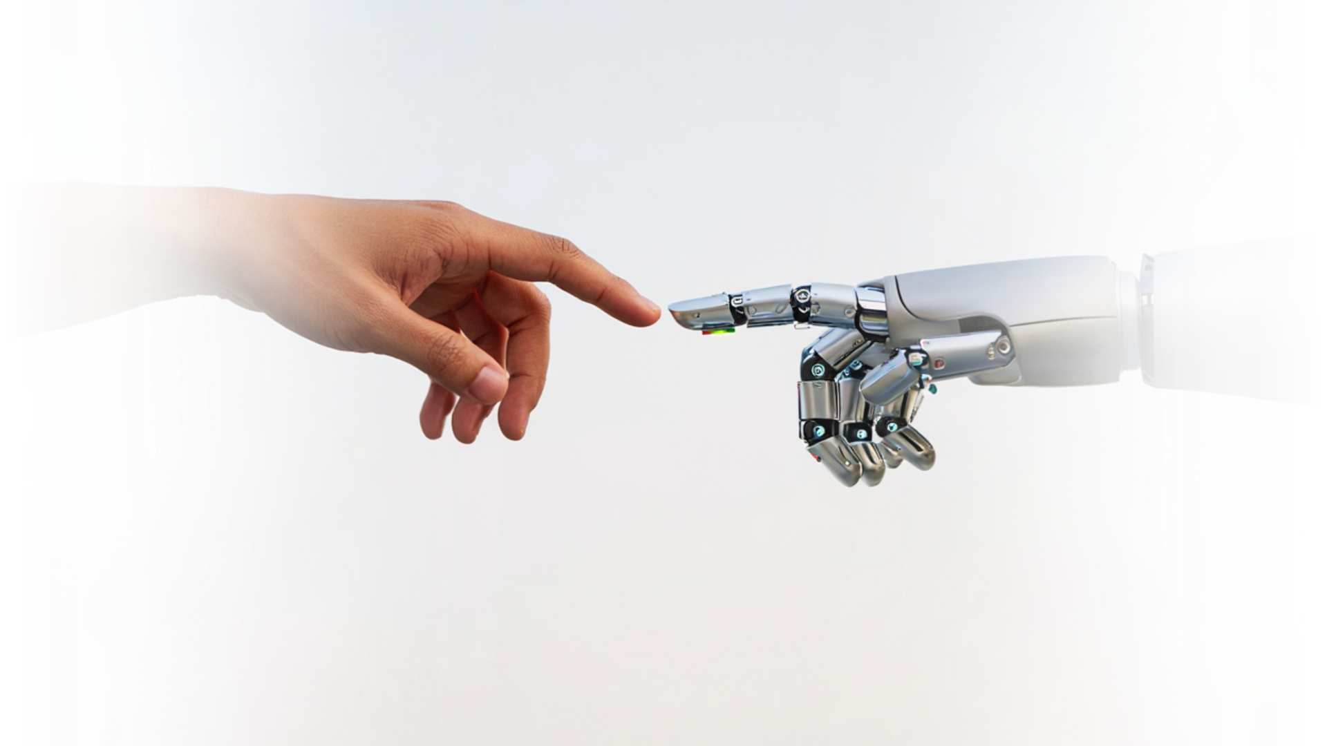 A human hand and a robotic hand reach toward each other, with their index fingers nearly touching against a plain background.