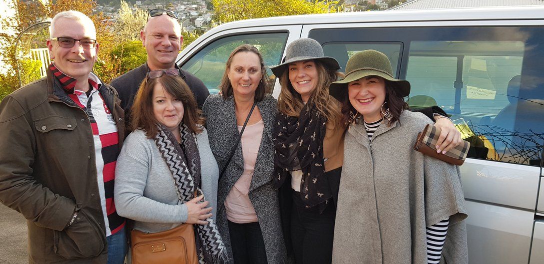 4 woman and 2 old guys infront of the van