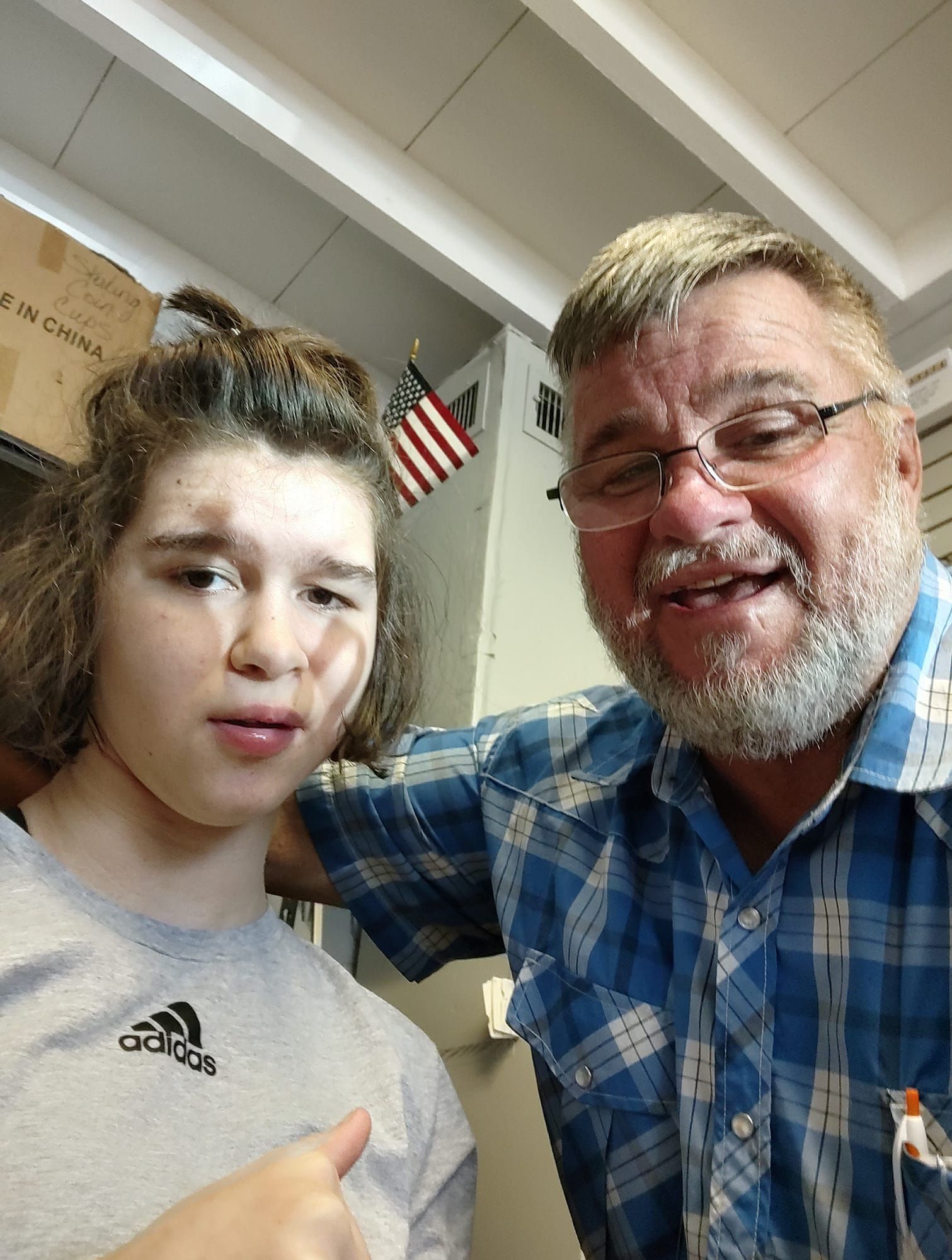 A man and a girl are posing for a picture and the girl is wearing an adidas shirt