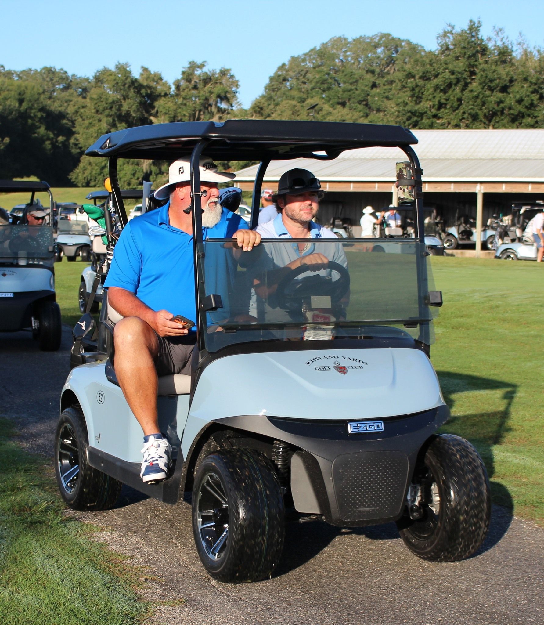 A man in a blue shirt is sitting in a golf cart