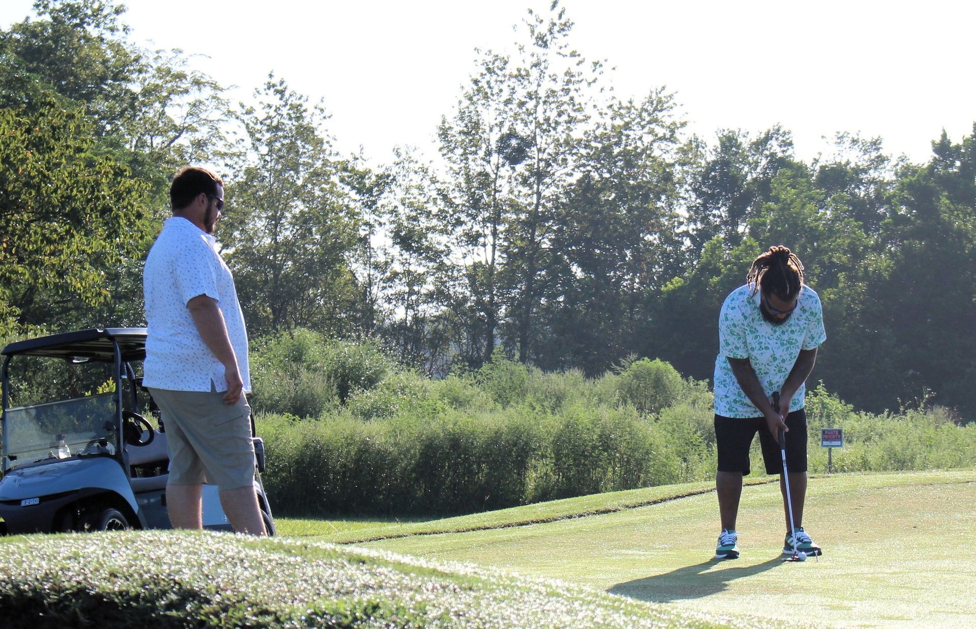 A man and a woman are playing golf on a golf course.