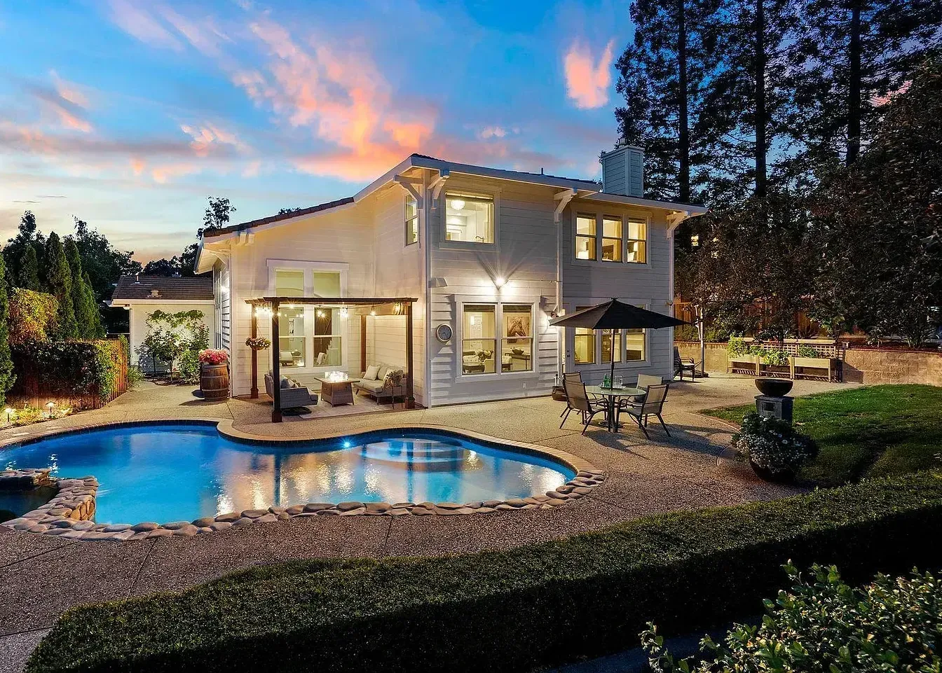A large white house with a large swimming pool in front of it