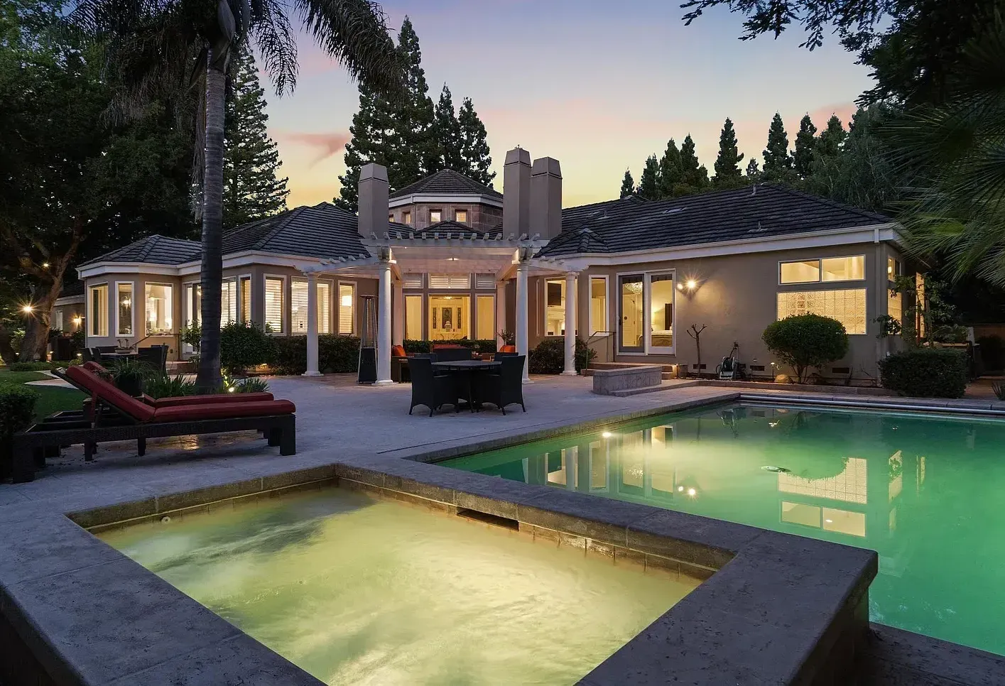 A large house with a swimming pool in front of it