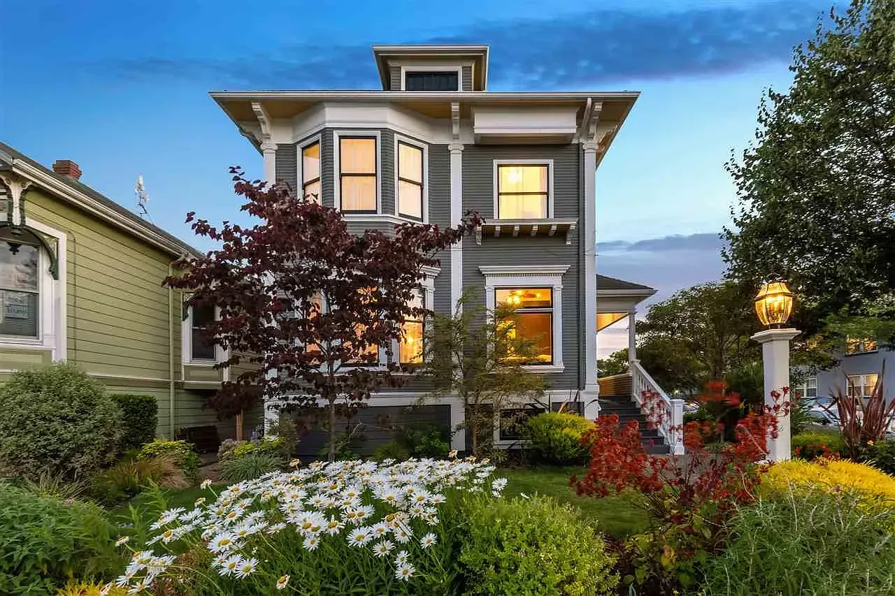A large house with a lot of windows and flowers in front of it.