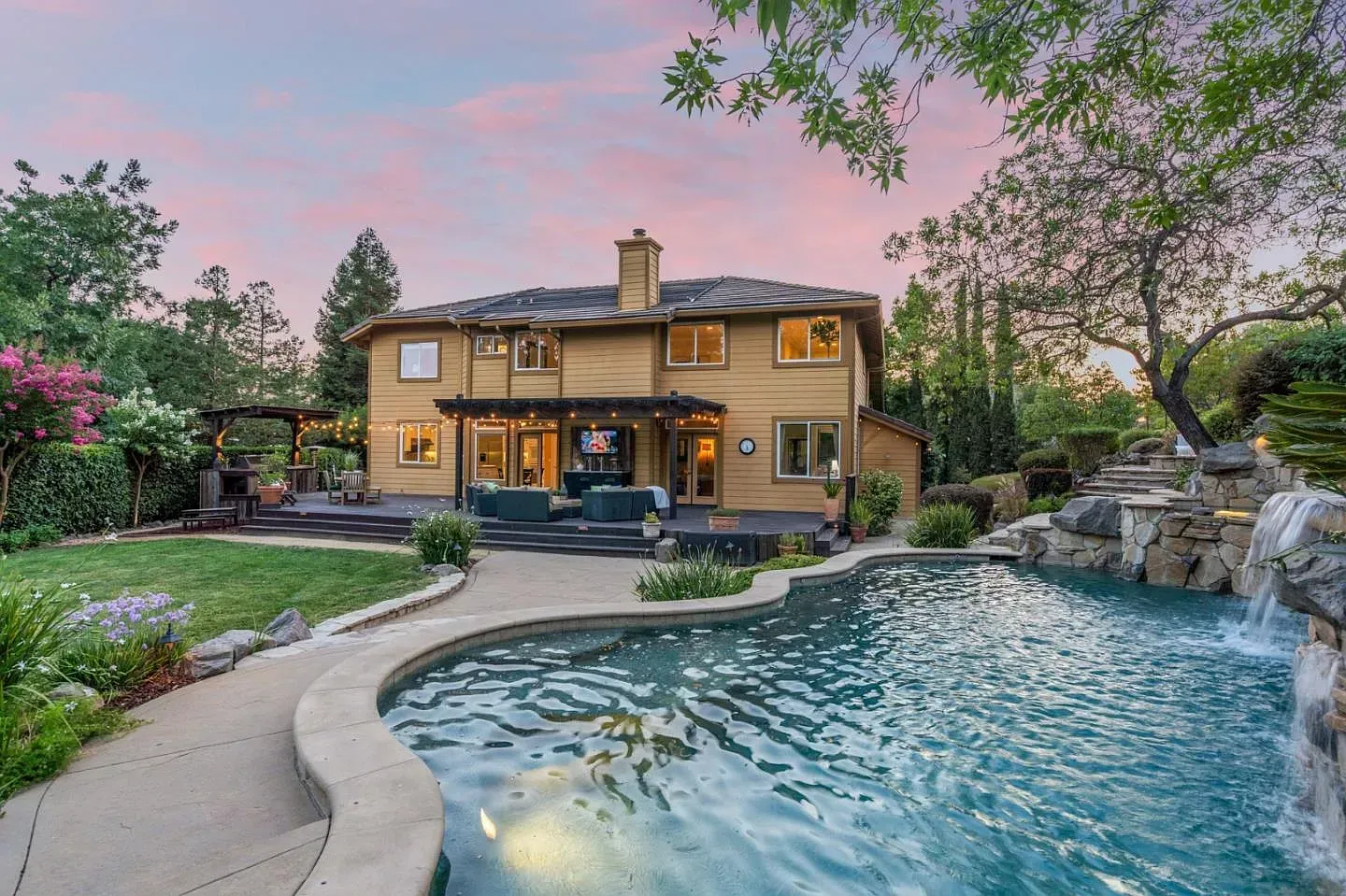 A large house with a swimming pool in front of it.