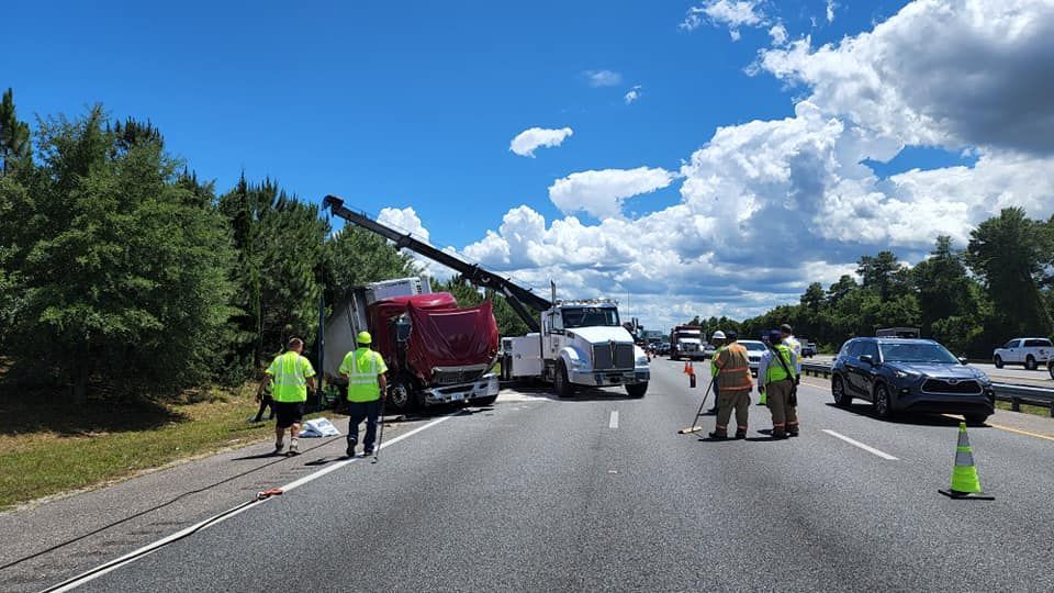 A group of people are standing on the side of a highway.
